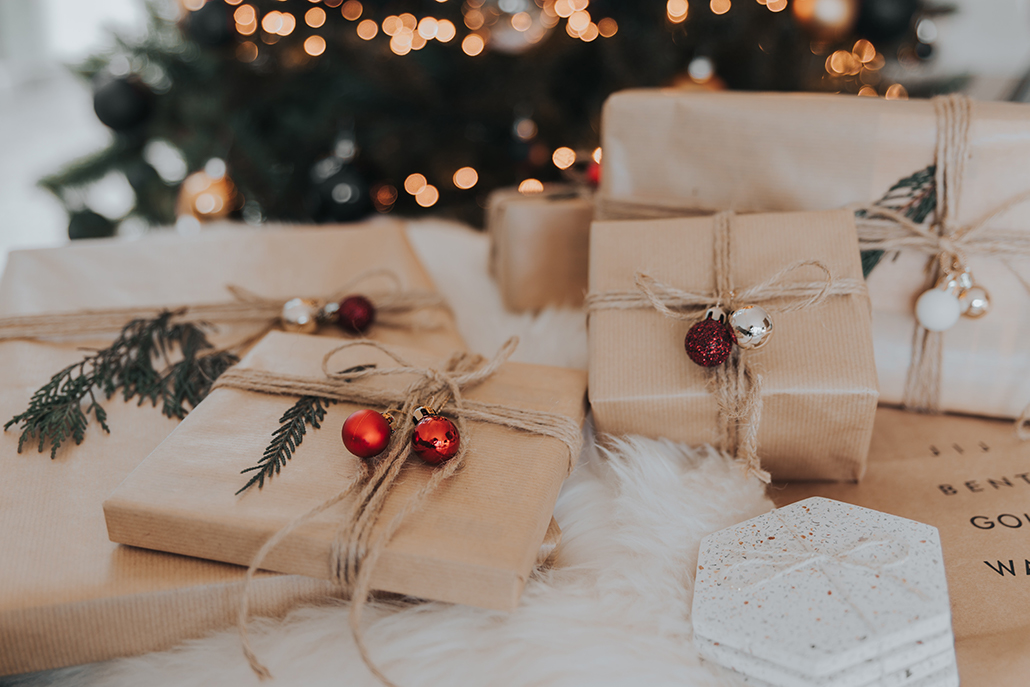 Presents wrapped in garment paper decorated with twine and ornament for Christmas.