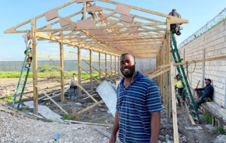 pastor poyis in front of trusses