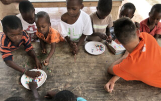 Haitian children doing arts and crafts with volunteers of C2M