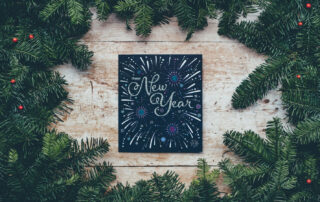 happy-new-year-greeting-on-table-surrounded-by-pine