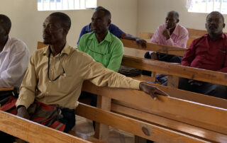 men listening to pastor speak inside a church