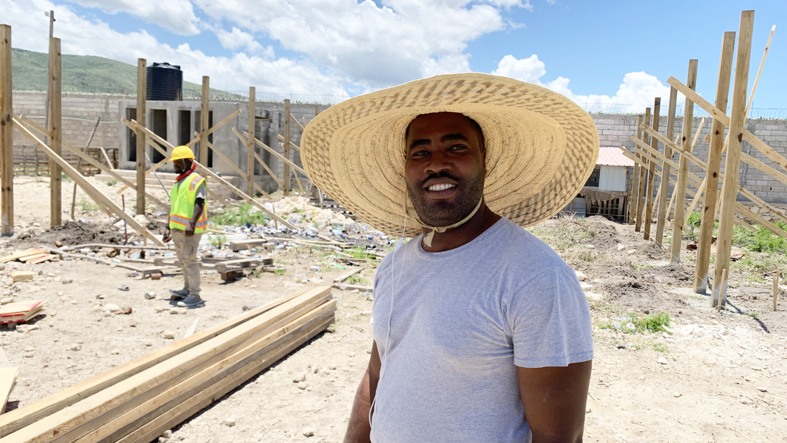 Pastor Poyis in a large sun hat with construction volunteers