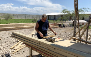 A carpenter volunteer measuring wood boards in Haiti