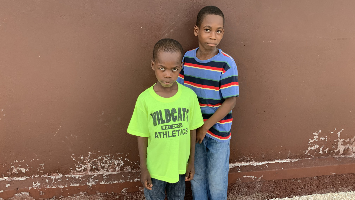 Two Haitian boys posing in front of a building