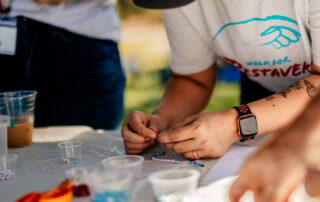 Simi walk participant making a bracelet.