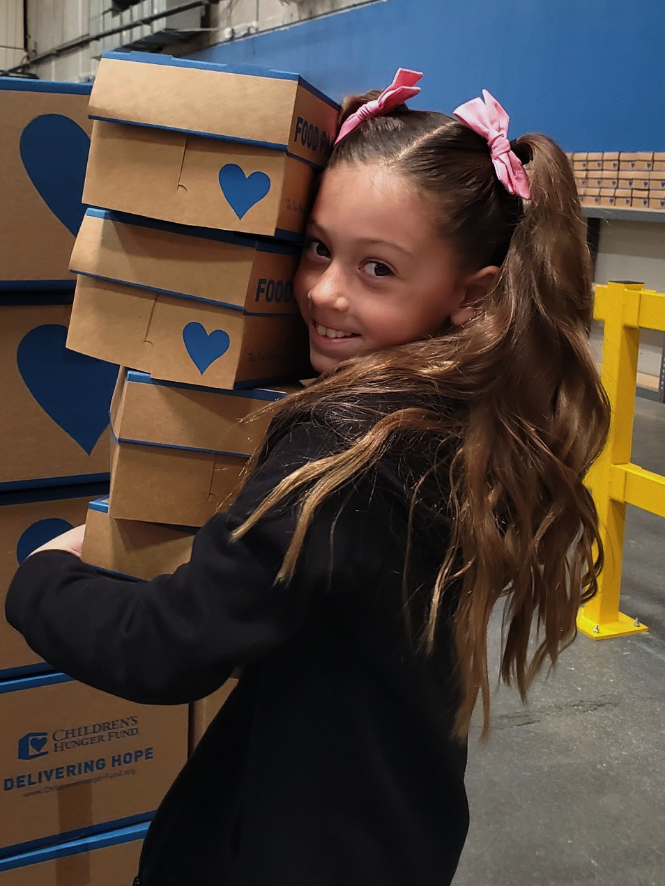 Young girl holding CHF care packages