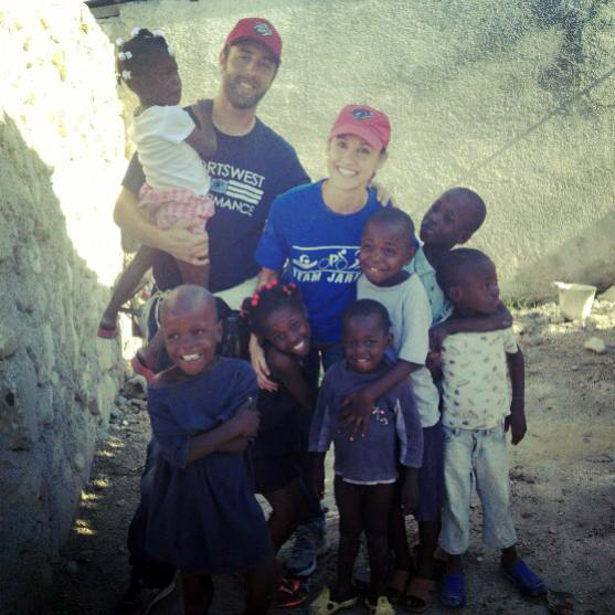 Vintage photo of the man and woman volunteers with Haitian children smiling and posing for a picture.