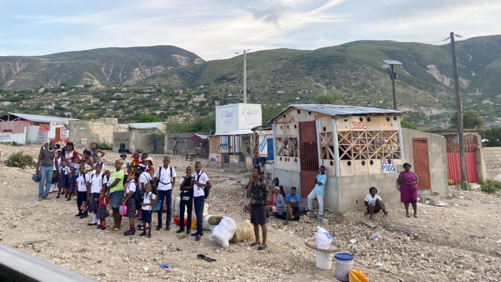 Haitian children and parents waiting for transportation.