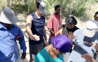 Praying in a circle over a Haitian woman.