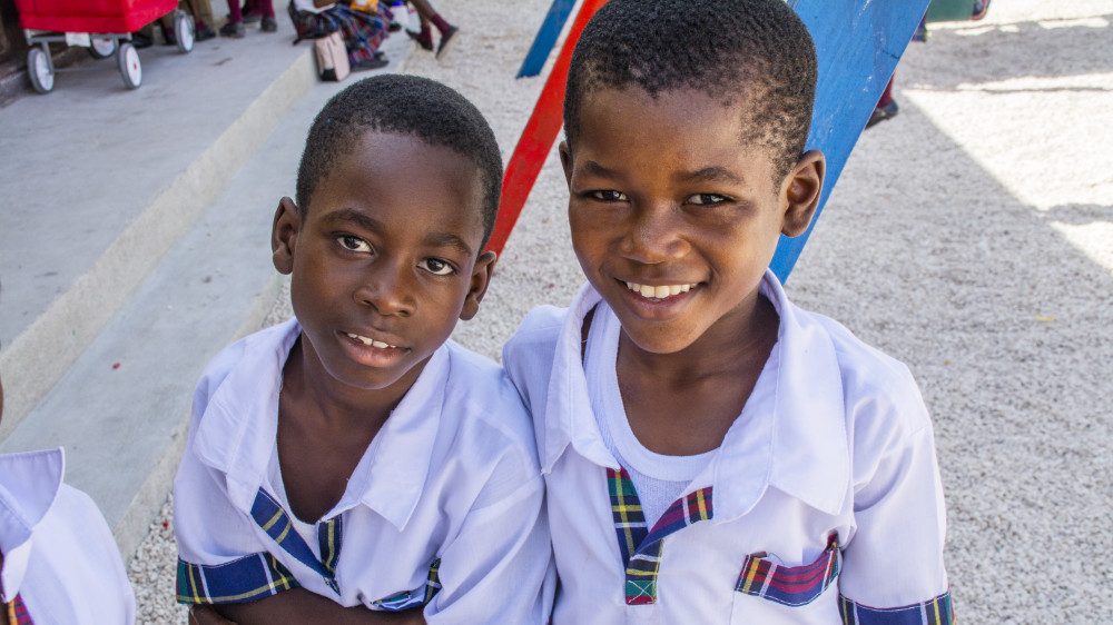 Male grade school students posing for a picture in school yard.