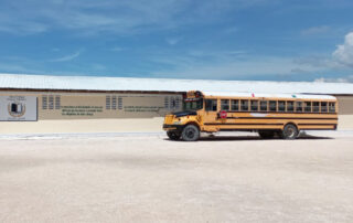 School Bus on a dirt lot in front of a church in Haiti.