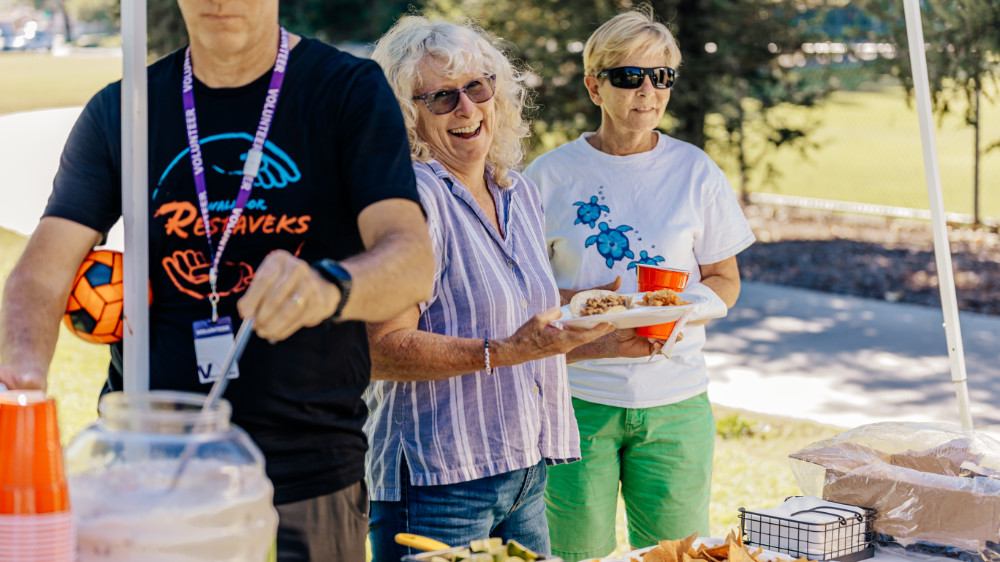 Volunteers eating in park.