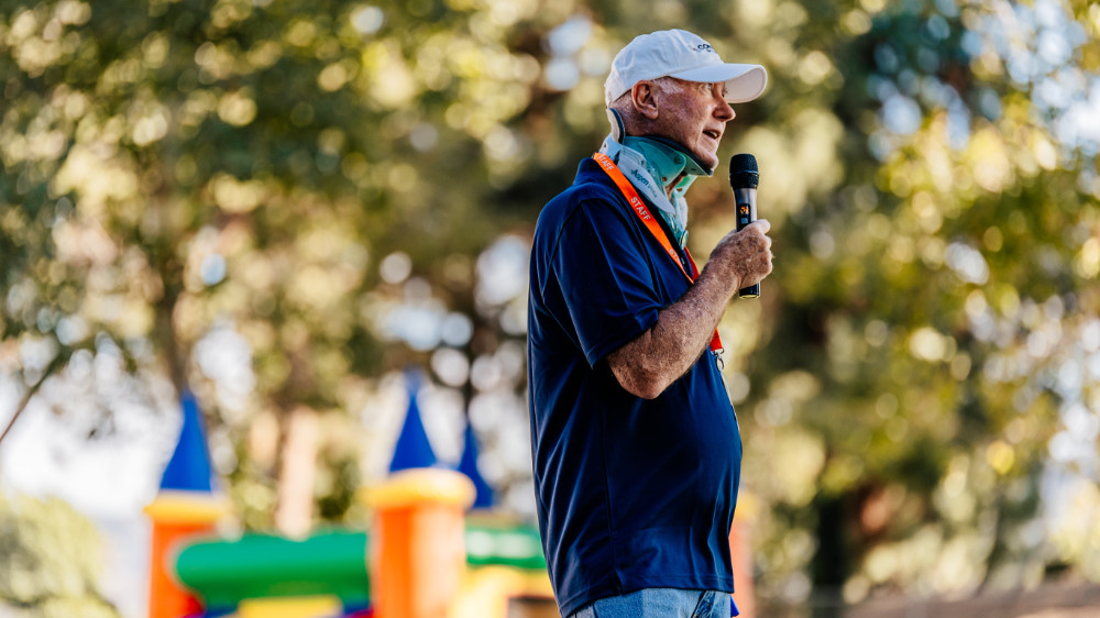 Greg speaking to a crowd at the park.