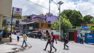 Citizens walking in busy intersection near a bank, in Haiti 2018.