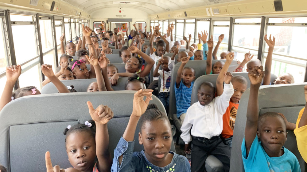 Haiti children happily riding in school bus