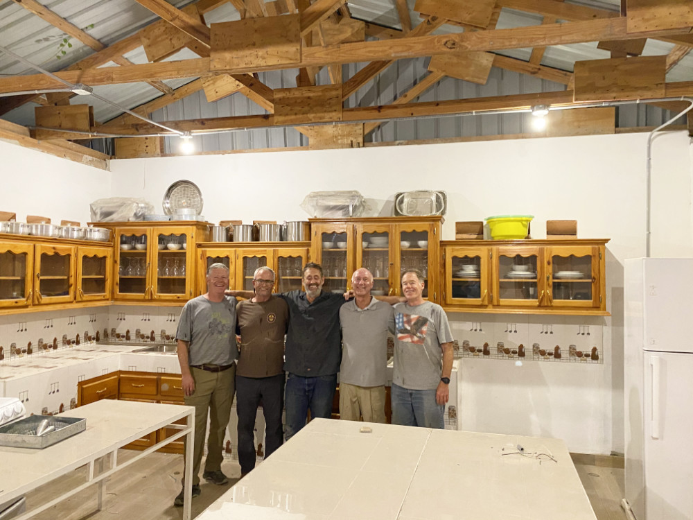 Greg in a kitchen with friends.